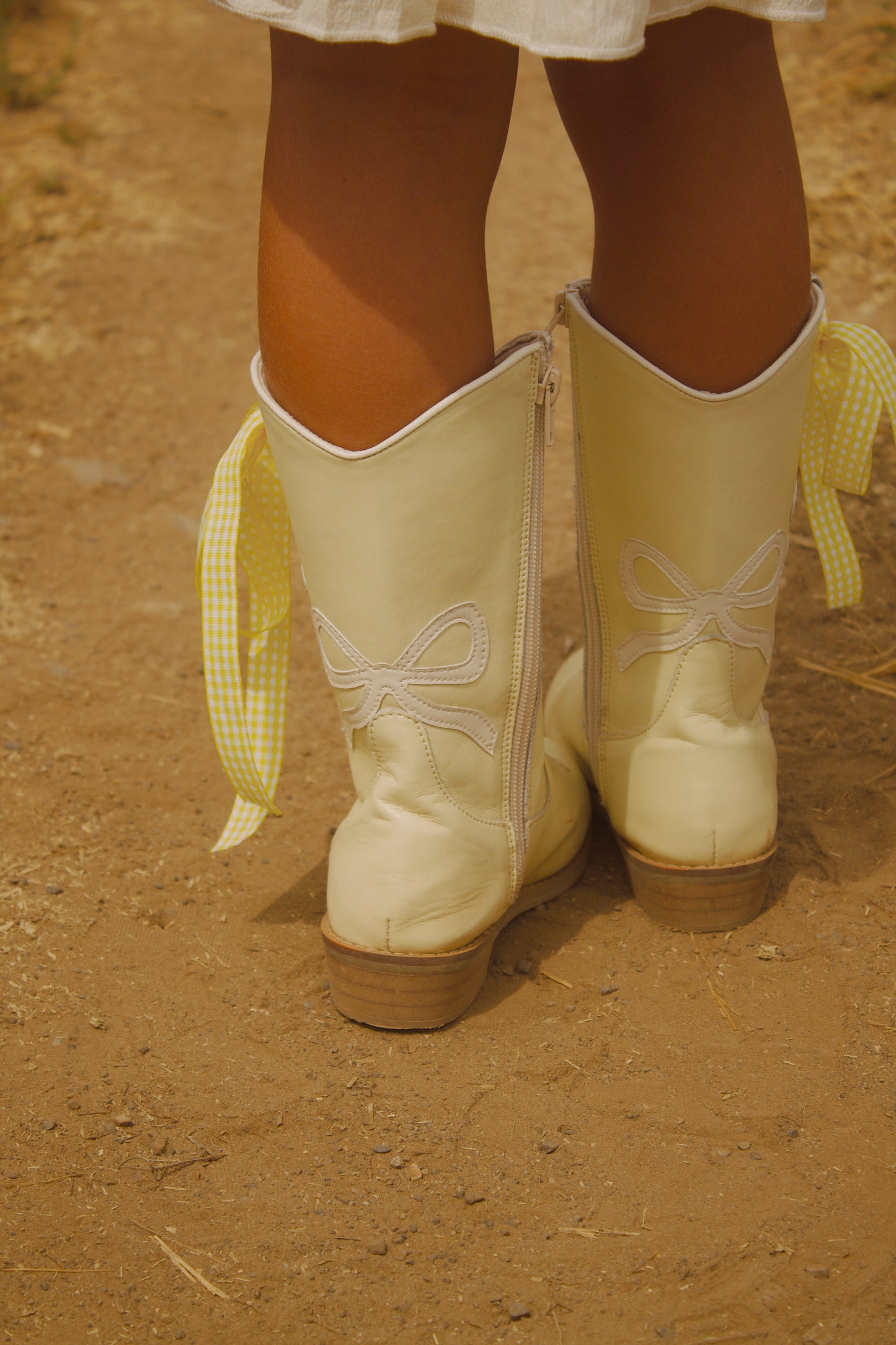 White bow on back of toddler cowgirl boots with daisy flower and metallic gold center – vegan leather Chasing Daisies boots