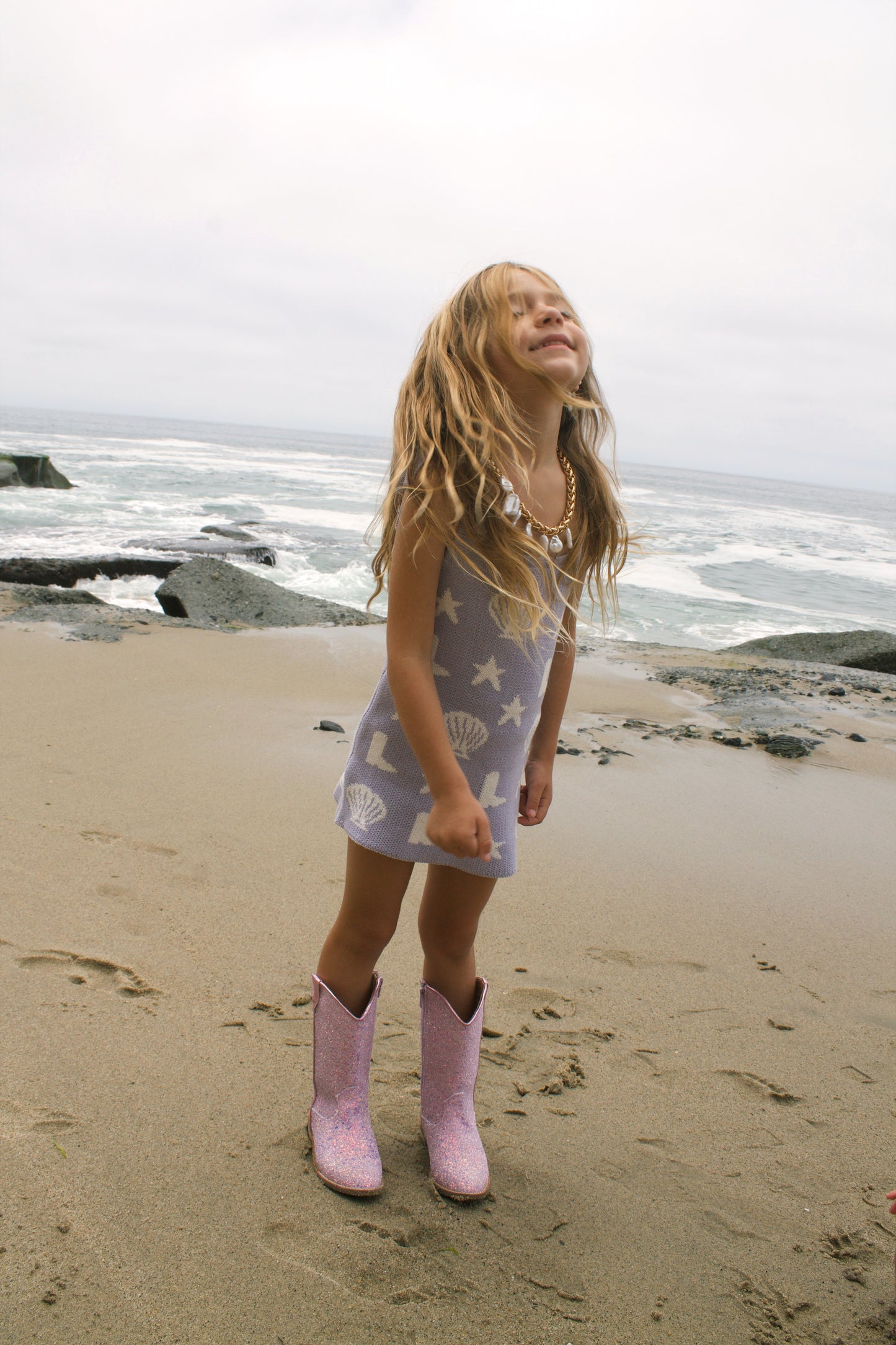 Coastal cowgirl lavender knit dress on the beach for toddler girls
