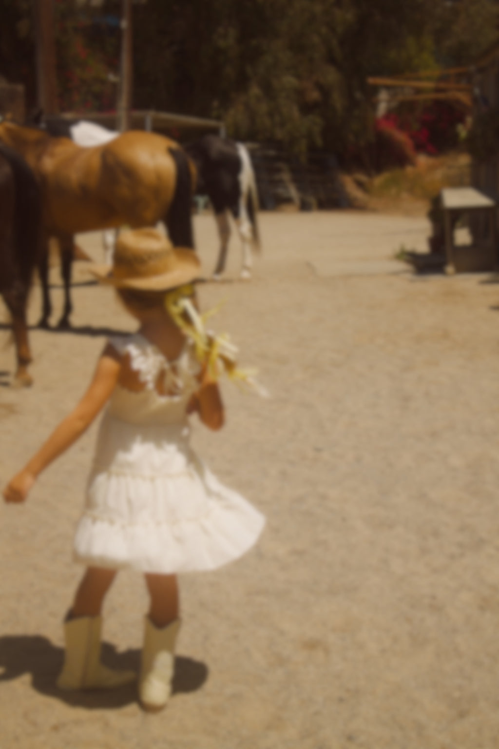 Little girl wearing a soft butter yellow cottagecore dress with flutter sleeves, posing outdoors in natural light. The dress has a vintage-inspired, dreamy feel—perfect for warm weather and whimsical adventures.