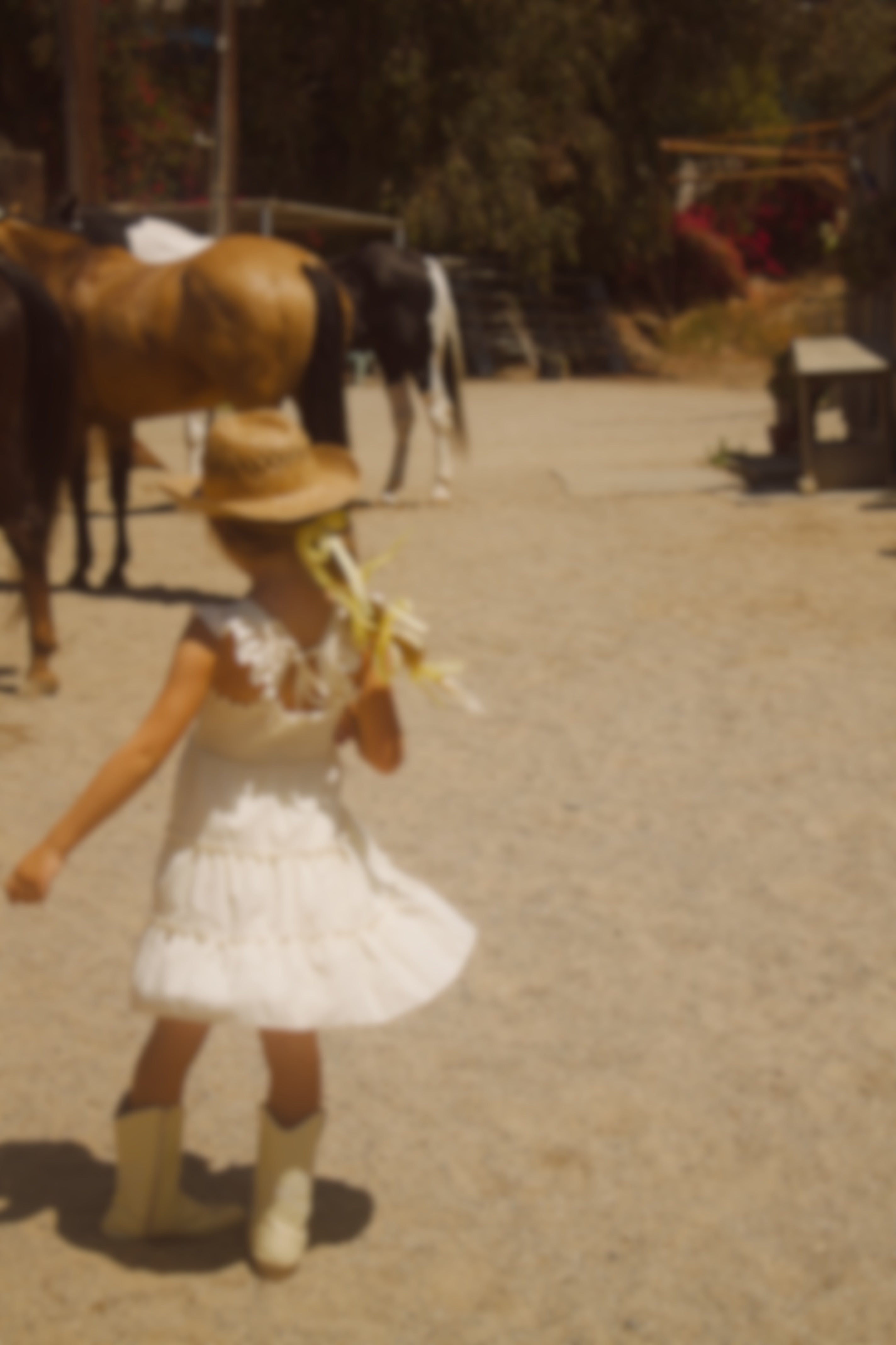 Little girl wearing a soft butter yellow cottagecore dress with flutter sleeves, posing outdoors in natural light. The dress has a vintage-inspired, dreamy feel—perfect for warm weather and whimsical adventures.