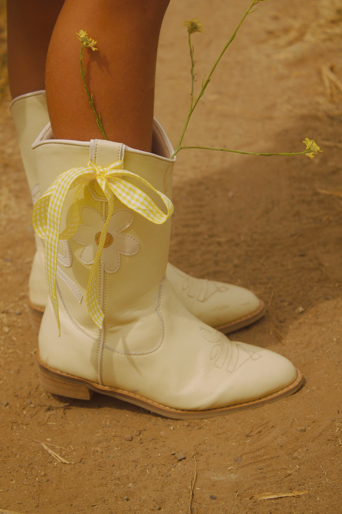 Butter yellow toddler cowgirl boots with white bow and daisy detail, made of vegan leather – Chasing Daisies Collection by Safehaven
