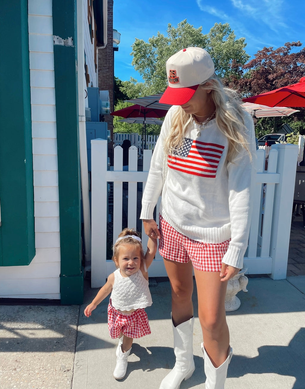 Mom and toddler holding hands in matching picnic shorts – red gingham mommy and me set